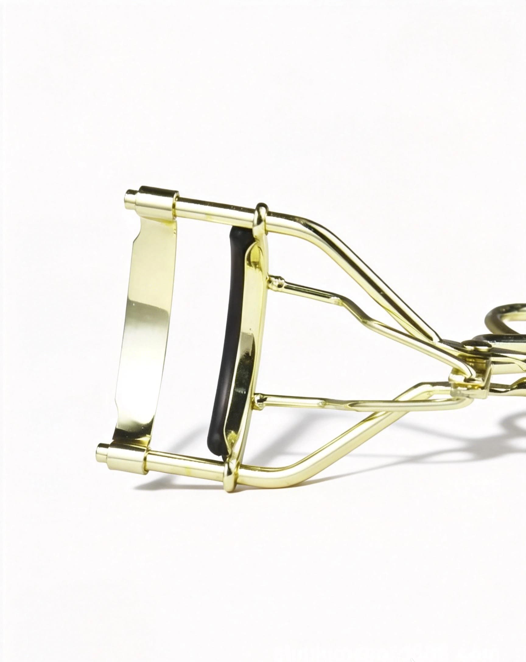 Finger-loop handles on the yellow gold metal eyelash curler