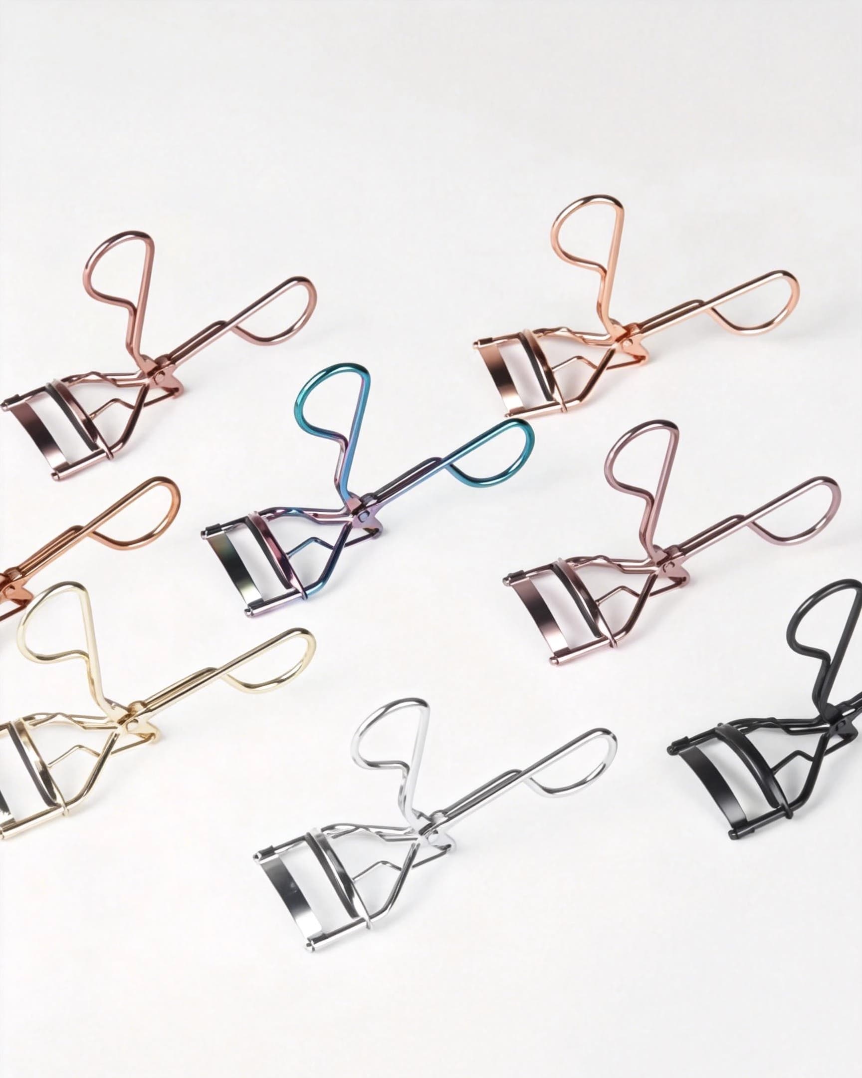 Full view of the yellow gold metal eyelash curler with loop handles