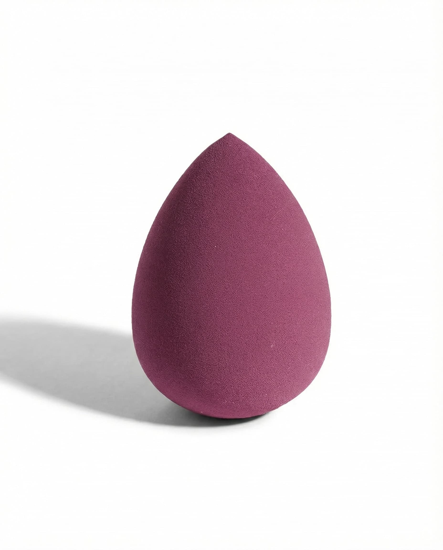Berry-colored egg-shaped makeup sponge with tapered tip