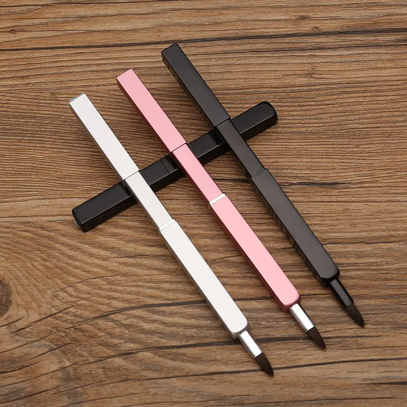Pink, silver and black square-body retractable lip brushes with pointed bristle heads on a wooden surface