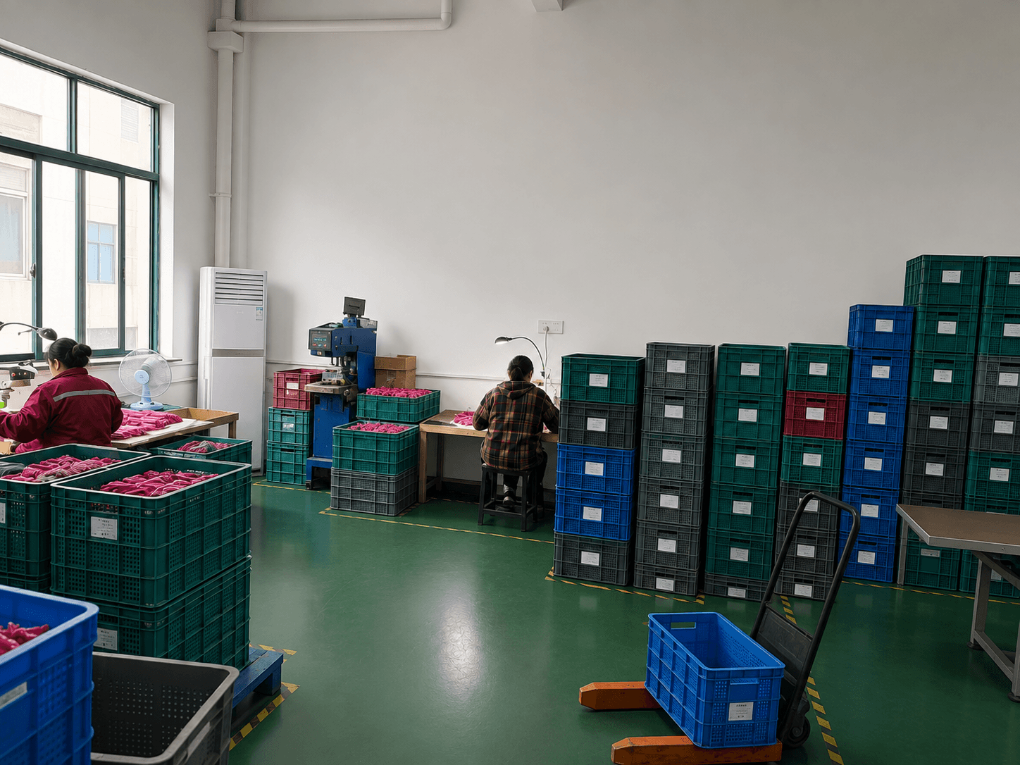 Workers processing pink beauty tool components at factory workstations