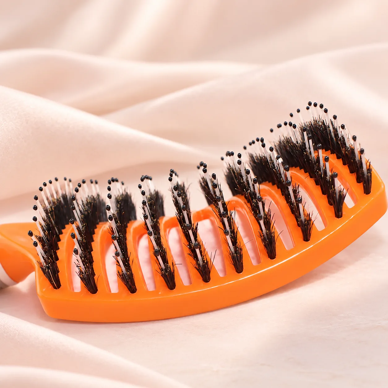 Close-up of orange BLC-03 showing short bristle tufts and longer ball-tipped pins